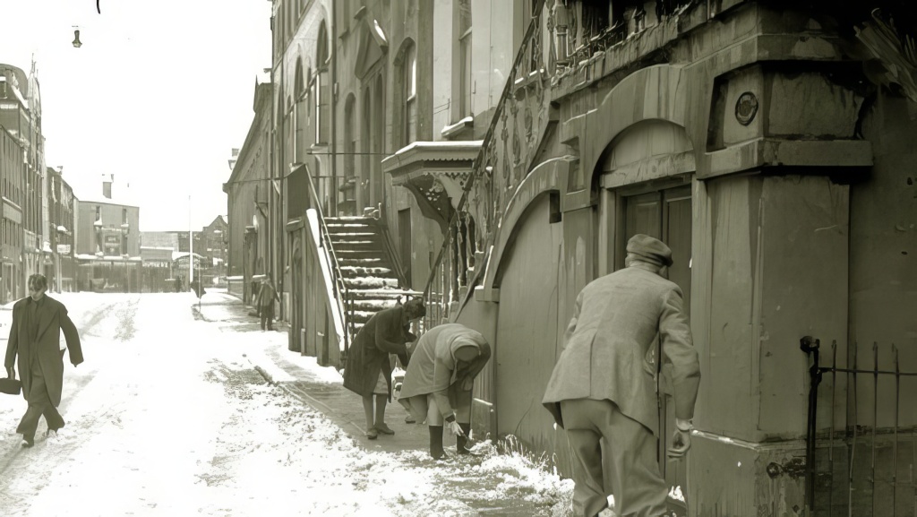 People clearing the snow from the pavement on Academy Street.